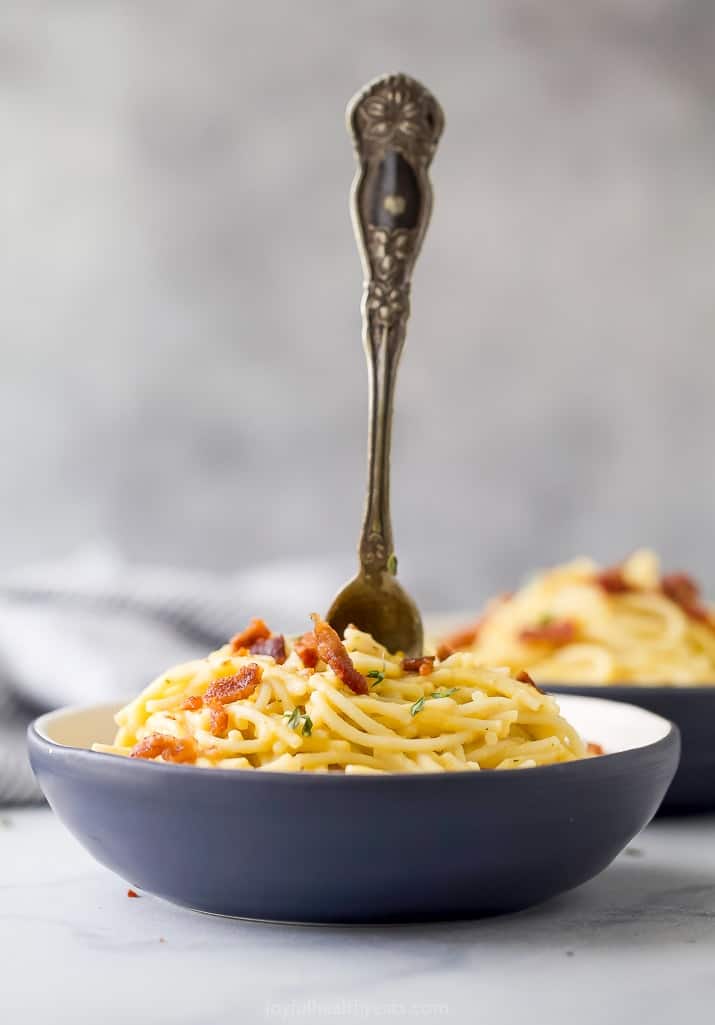 a bowl of creamy butternut squash pasta with a fork in it