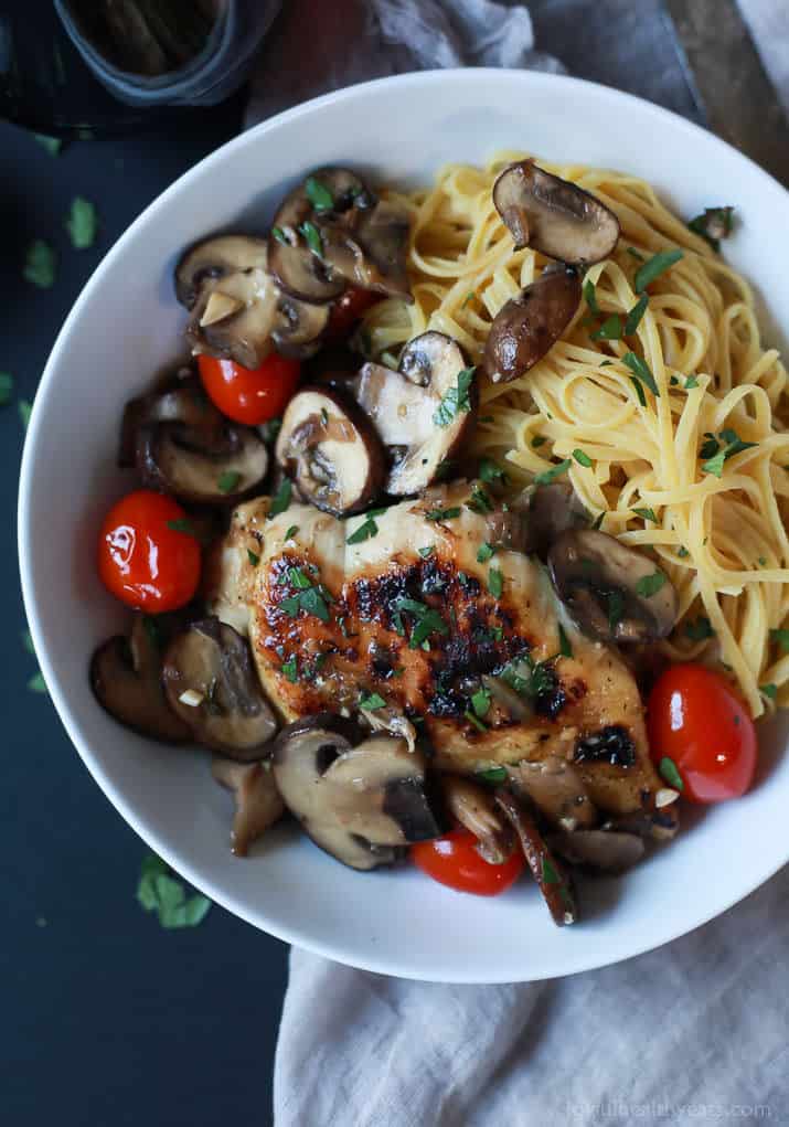 Top view of Chicken Marsala topped with Blistered Tomatoes served over pasta in a bowl