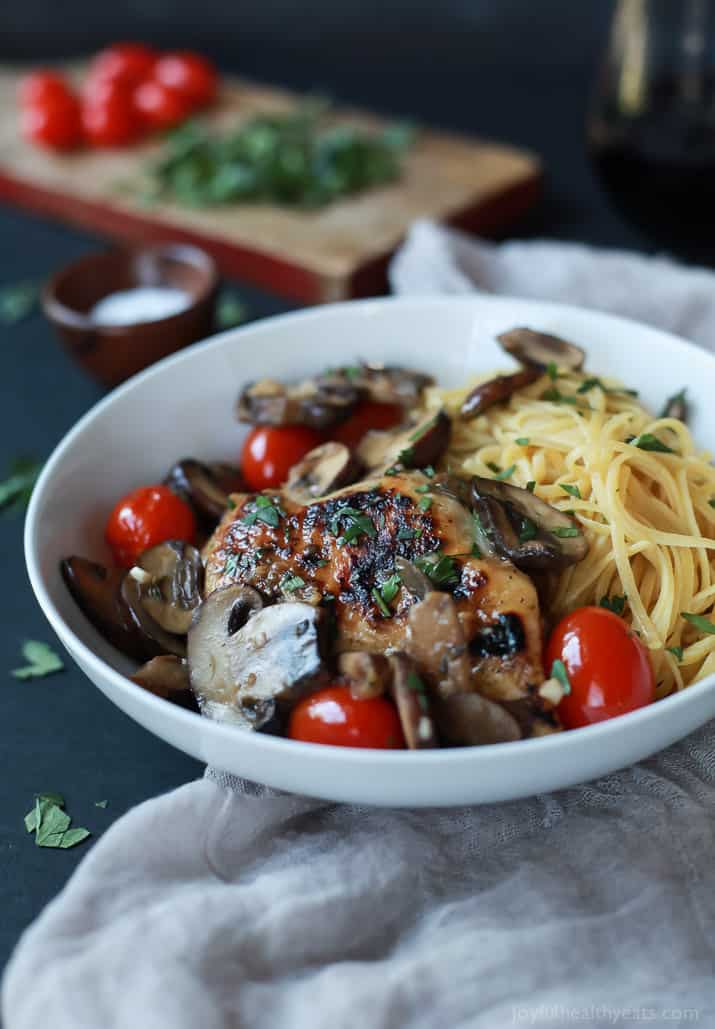 Chicken Marsala topped with Blistered Tomatoes over pasta in a bowl