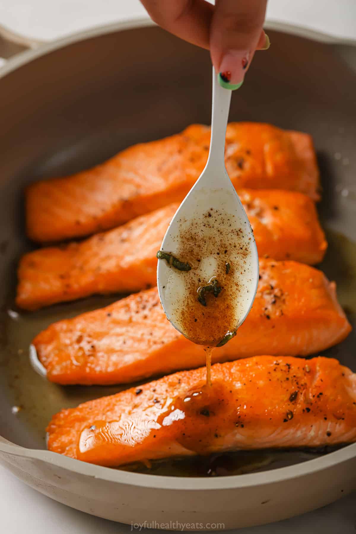 Spooning the brown butter sauce over the salmon. 