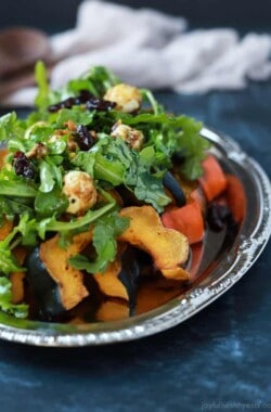 A perfect vegetarian side dish for the fall, Roasted Acorn Squash topped with a fresh Arugula Salad that's mixed with dried cherries and goat cheese balls coated with salty pistachios. De-lish! | joyfulhealthyeats.com #recipes #glutenfree #vegetarian