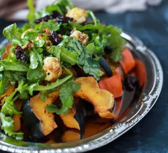 A perfect vegetarian side dish for the fall, Roasted Acorn Squash topped with a fresh Arugula Salad that's mixed with dried cherries and goat cheese balls coated with salty pistachios. De-lish! | joyfulhealthyeats.com #recipes #glutenfree #vegetarian