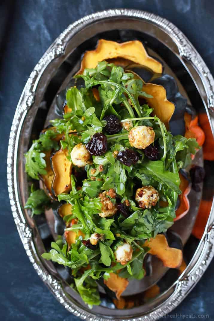 A perfect vegetarian side dish for the fall, Roasted Acorn Squash topped with a fresh Arugula Salad that's mixed with dried cherries and goat cheese balls coated with salty pistachios. De-lish! | joyfulhealthyeats.com #recipes #glutenfree #vegetarian