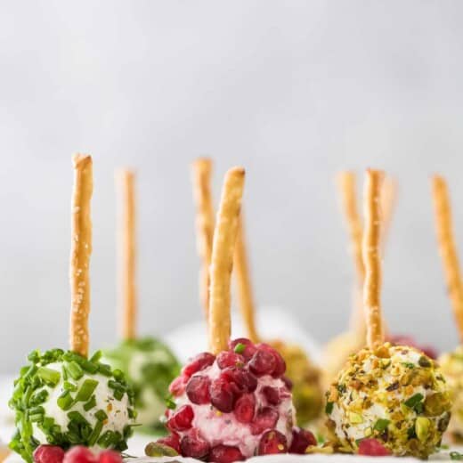 No-bake cheese balls lined up on a cutting board covered with parchment paper