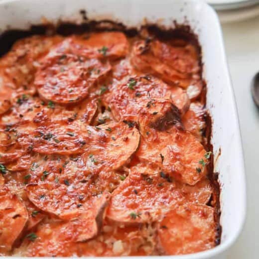 Scalloped sweet potatoes in a casserole dish.