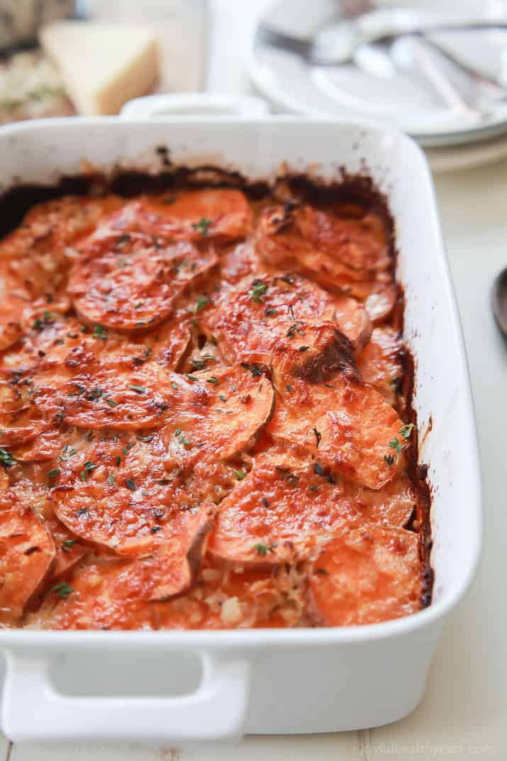 Cheesy scalloped sweet potatoes topped with fresh herbs.