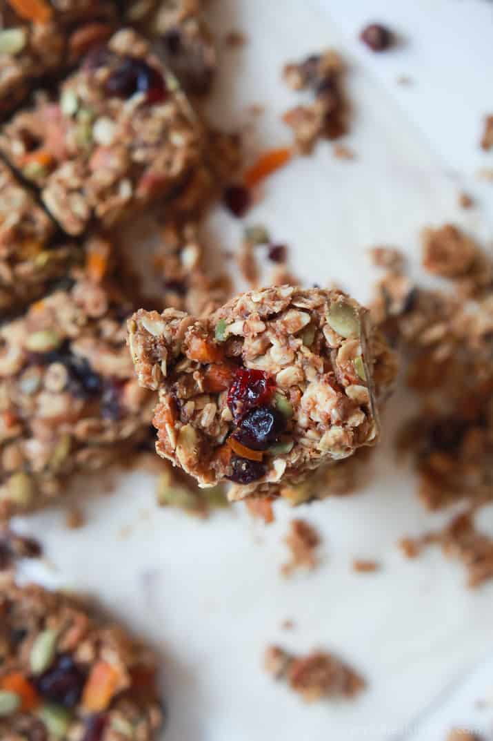 A pumpkin spice granola bar stacked on top of a second bar over a sheet of parchment paper