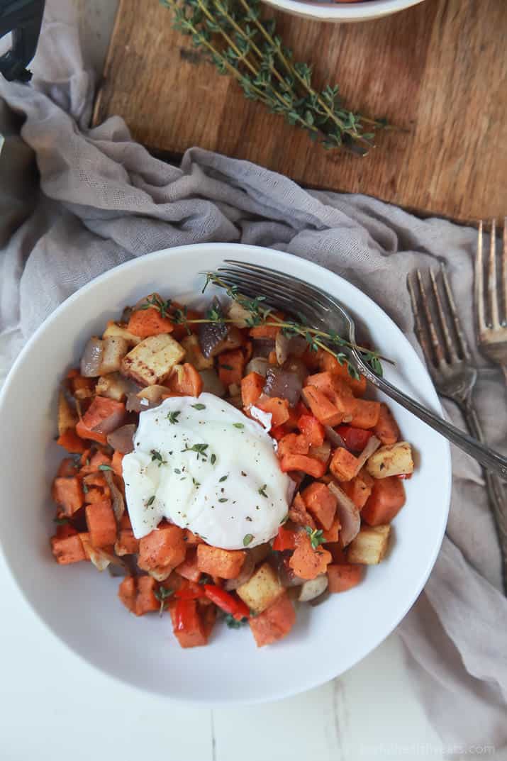 Top view of a bowl of Sweet Potato Hash topped with a Poached Egg