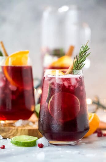 the ultimate holiday sangria recipe in a glass with garnishes
