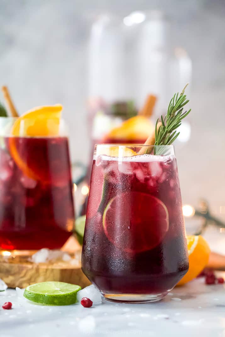 the ultimate holiday sangria recipe in a glass with garnishes