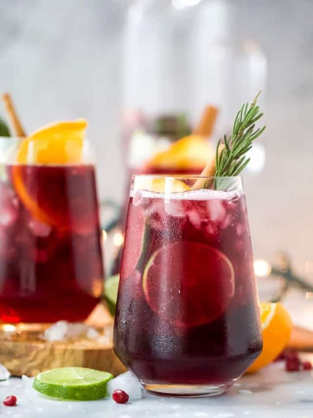the ultimate holiday sangria recipe in a glass with garnishes