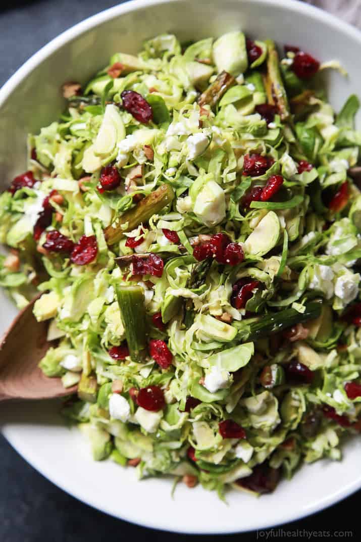 Asparagus & Brussel Sprout Salad topped with Honey Dijon Dressing in a bowl