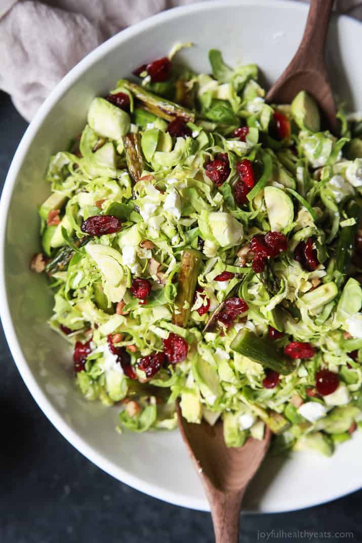 Asparagus & Brussel Sprout Salad topped with dried cranberries and Honey Dijon Dressing