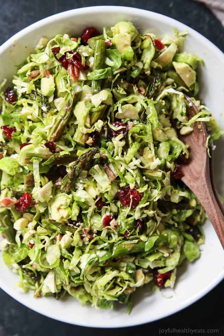 Asparagus & Brussel Sprout Salad topped with Honey Dijon Dressing in a bowl