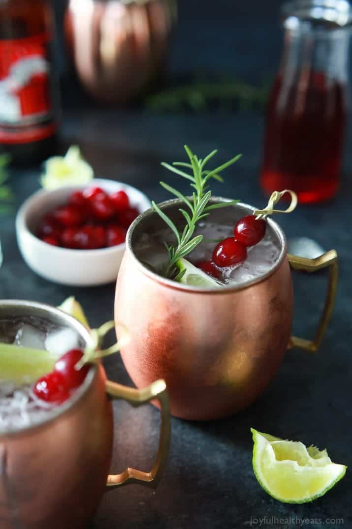 Two mugs of Cranberry Moscow Mule with Rosemary Infused Vodka