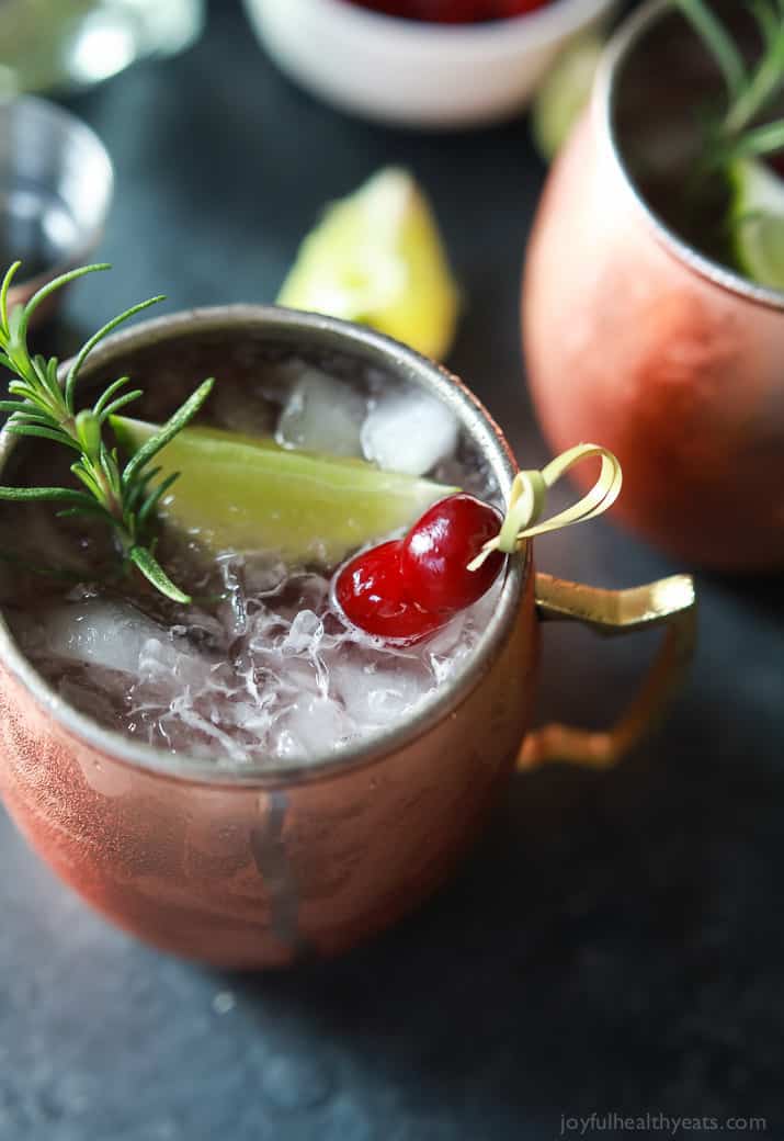 Close-up view of a copper mug of Cranberry Moscow Mule with Rosemary Infused Vodka
