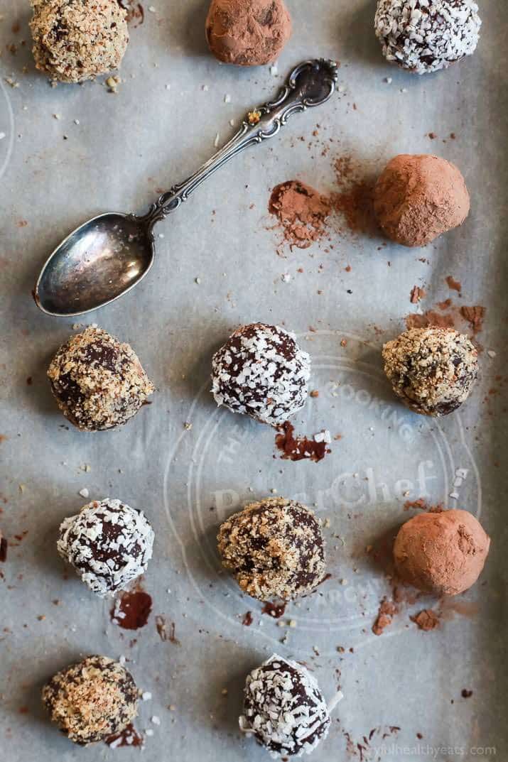 Top view of round Chocolate Truffles with a variety of toppings on parchment paper
