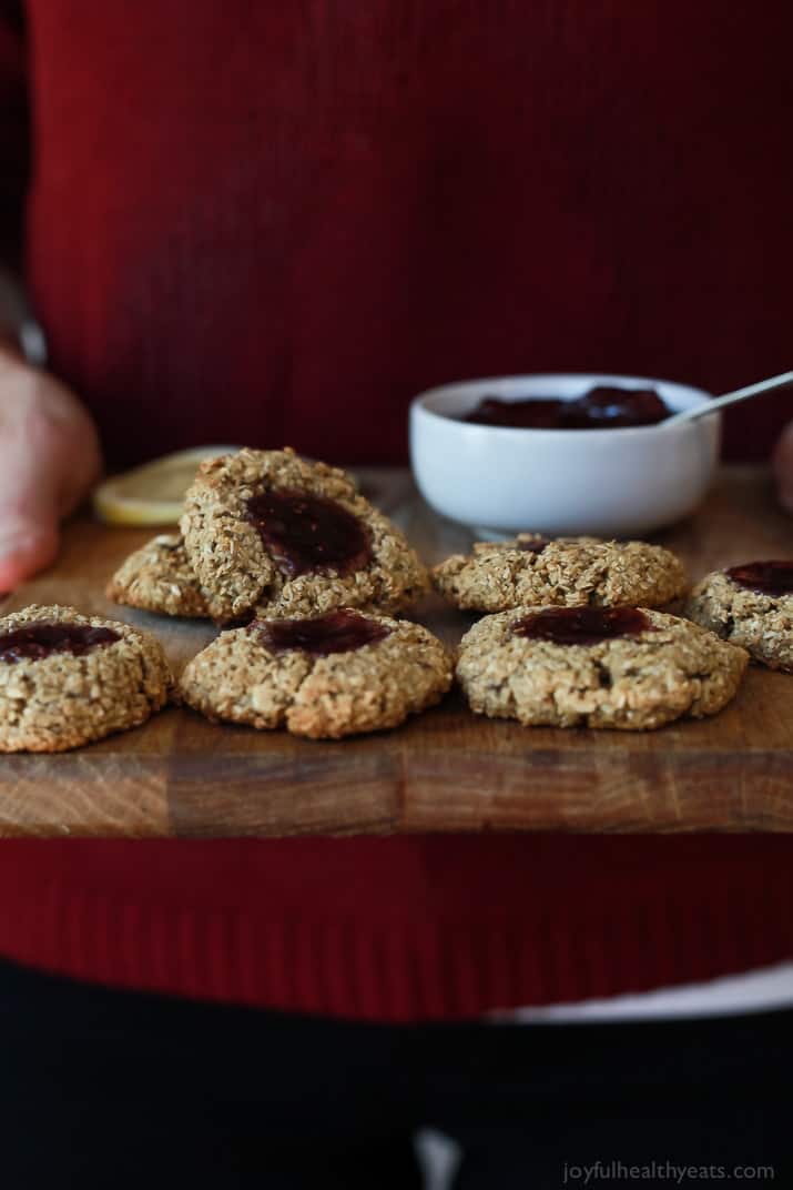 Side view of Flourless Lemon Raspberry Thumbprint Cookies on a wooden board