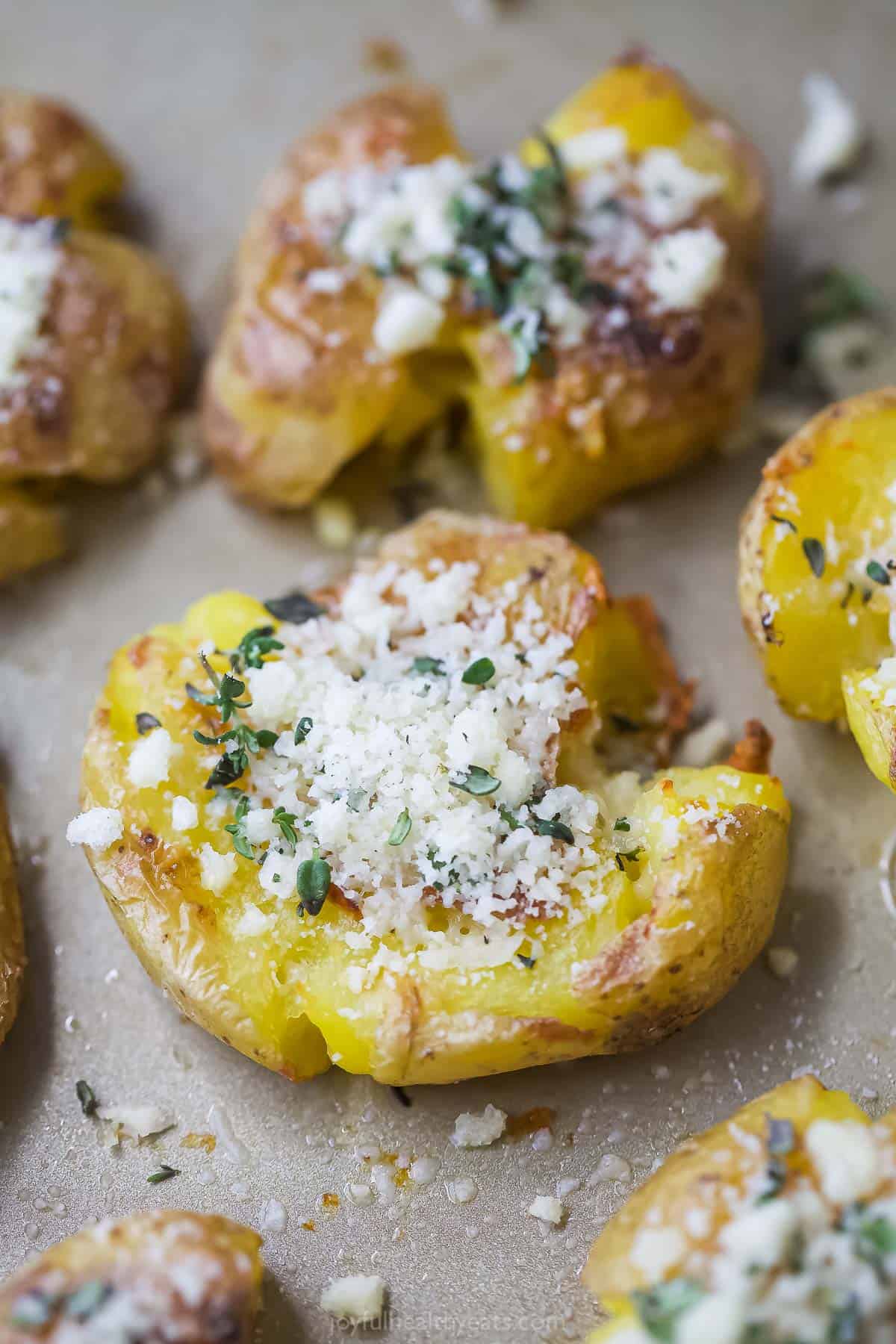 Close-up of smashed potatoes with garlic-herb mixture on top. 