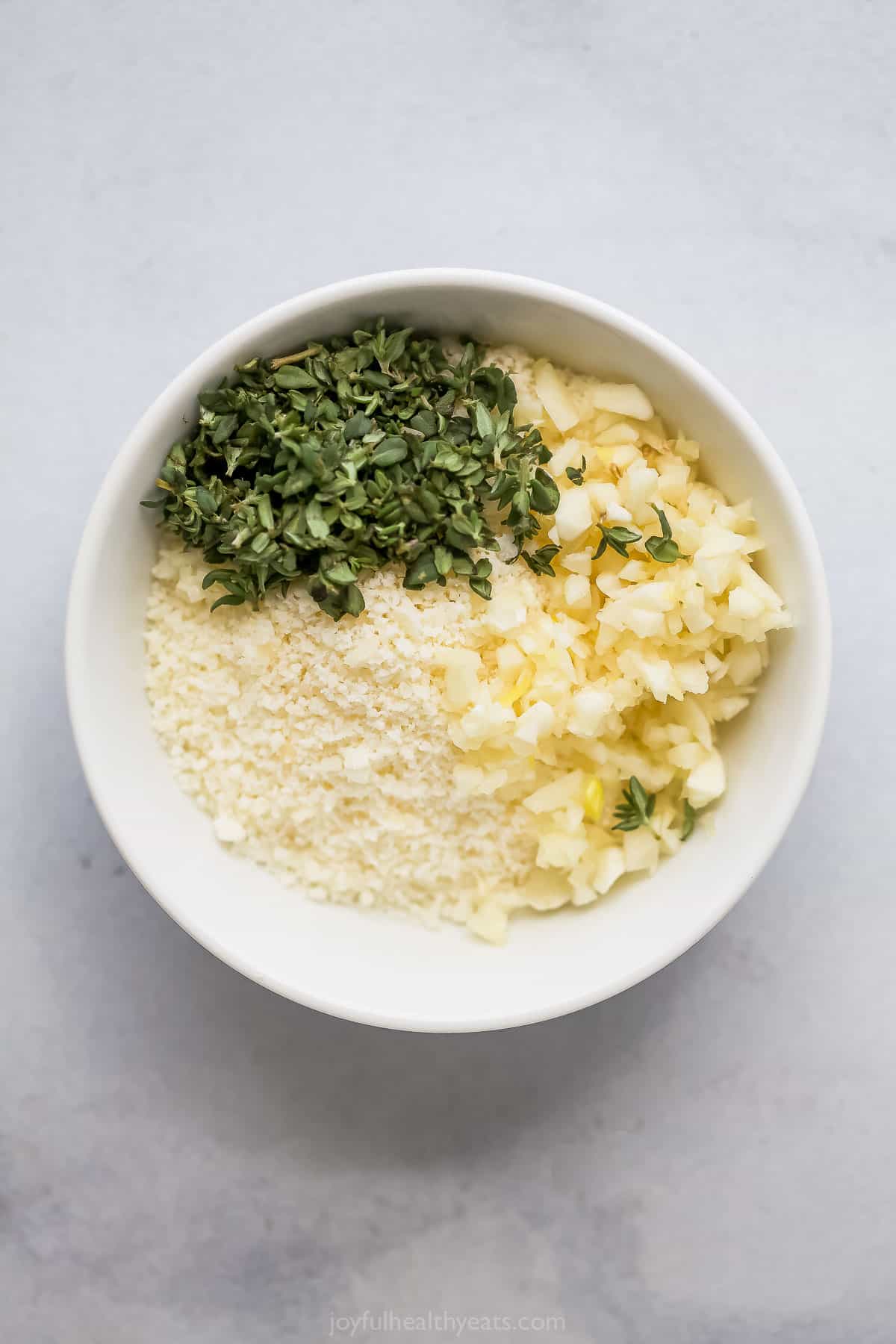 Ingredients for the garlic-herb mixture in a bowl. 