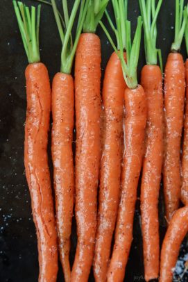 Eight Honey Mustard Glazed Carrots Lined Up on a Baking Sheet