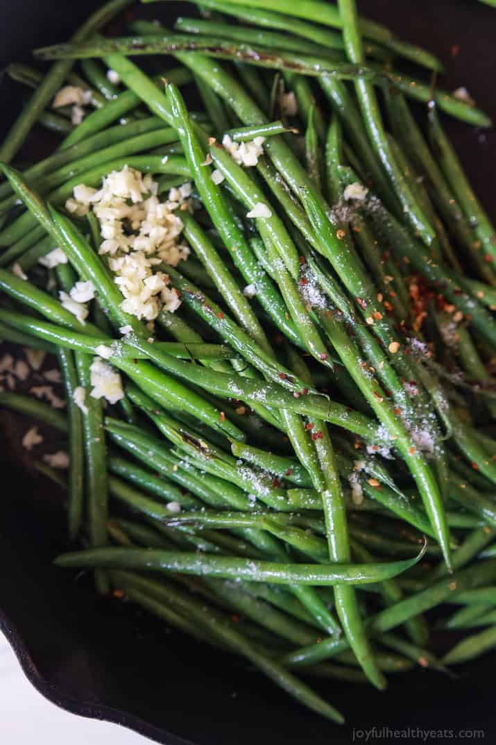 Green Beans in a Skillet Topped with Minced Garlic and Red Pepper Flakes