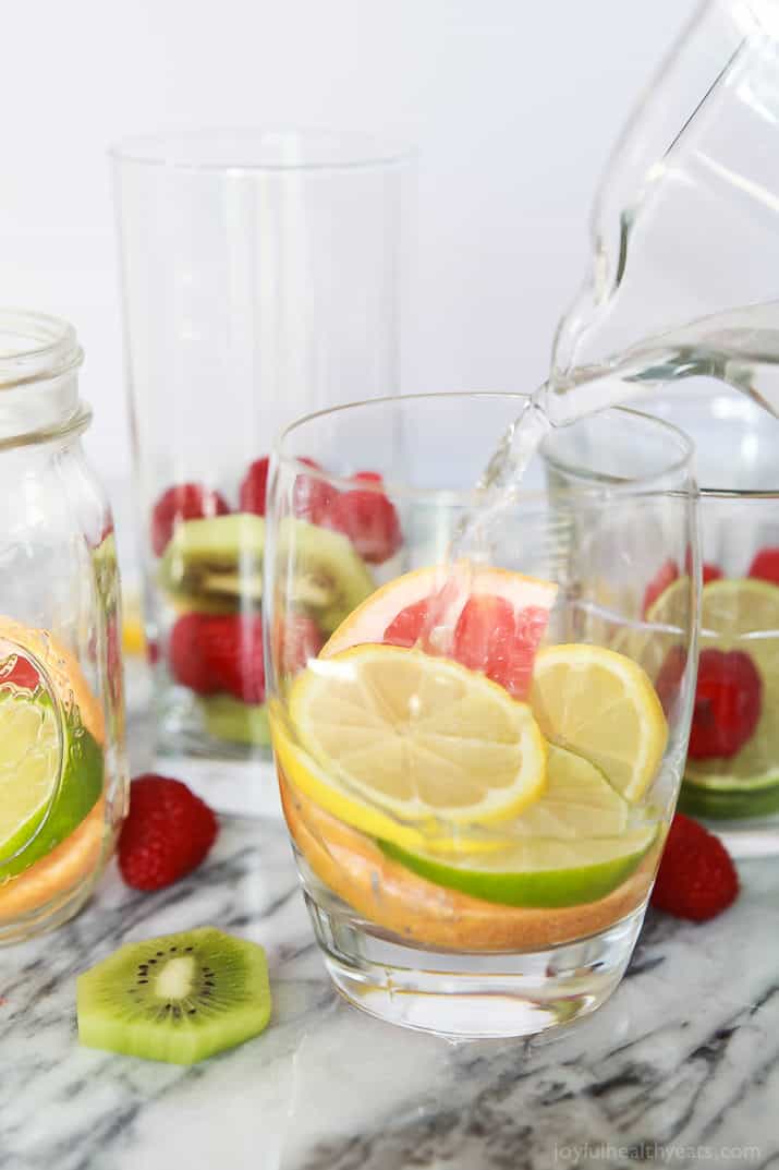 Water being added to fruit in a glass to make Fruit Infused Water