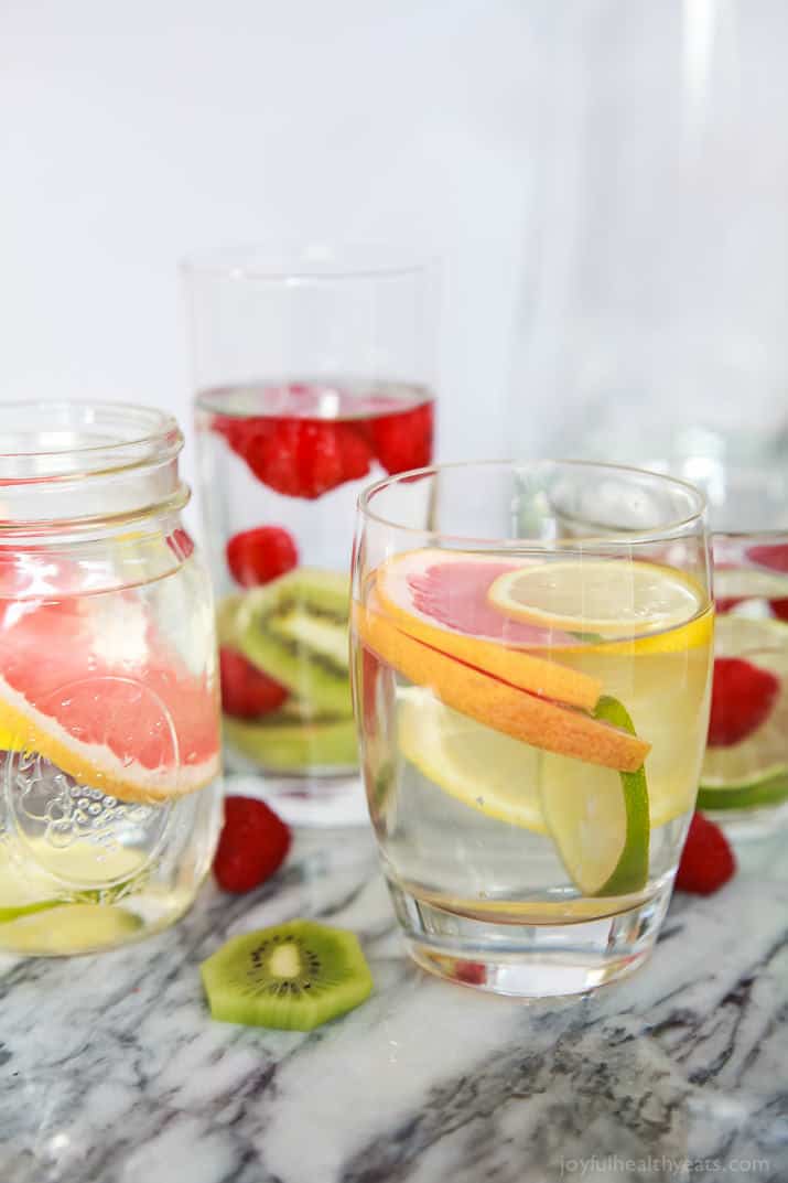 These fruit infused water recipes with berries, citrus, and kiwi are a tropical, refreshing way to feel like you're having a spa day at home. Three different kinds of fruit infused water in serving glasses.