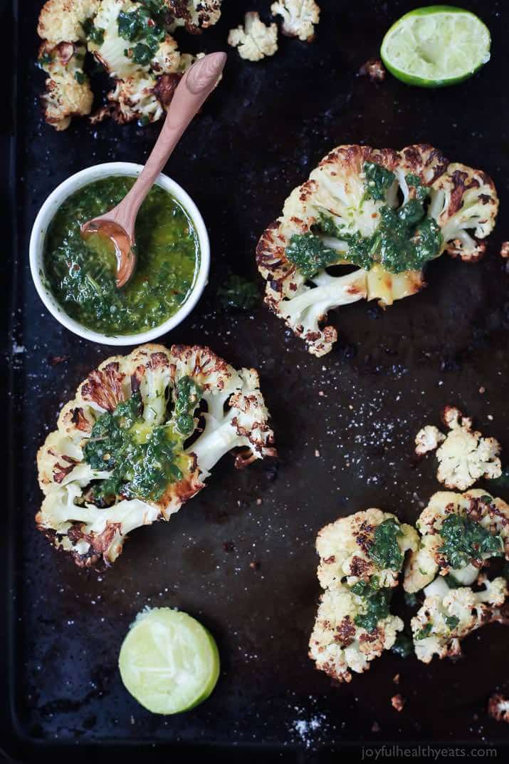 Easy naturally Gluten Free Roasted Cauliflower Steaks topped with fresh zesty Chimichurri Sauce at only 106 calories. Who knew Cauliflower could taste so good! This recipe is down right addicting! | joyfulhealthyeats.com