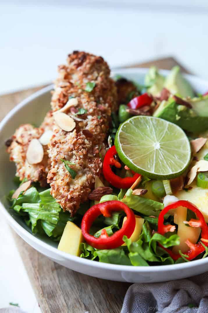 Change up your salad game with this Tropical Coconut Chicken Salad filled with fresh exotic fruits and homemade almond-coconut crusted chicken tenders. It's a swoon worthy salad that'll take you to the beach and you'll want to repeat all week! | joyfulhealthyeats.com