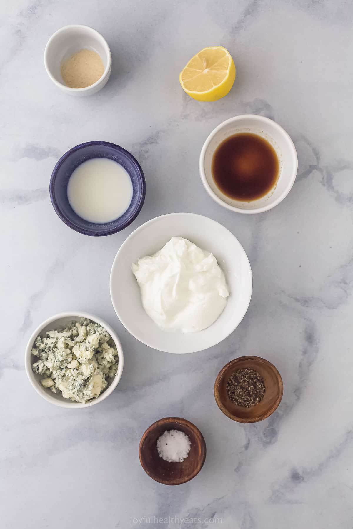 Ingredients to make creamy blue cheese dressing like blue cheese, salt, pepper, worcestershire sauce, cream, and sour cream