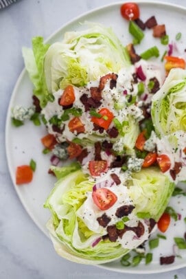 Wedge Salad with iceberg lettuce, tomatoes, bacon, red onions and creamy dressing