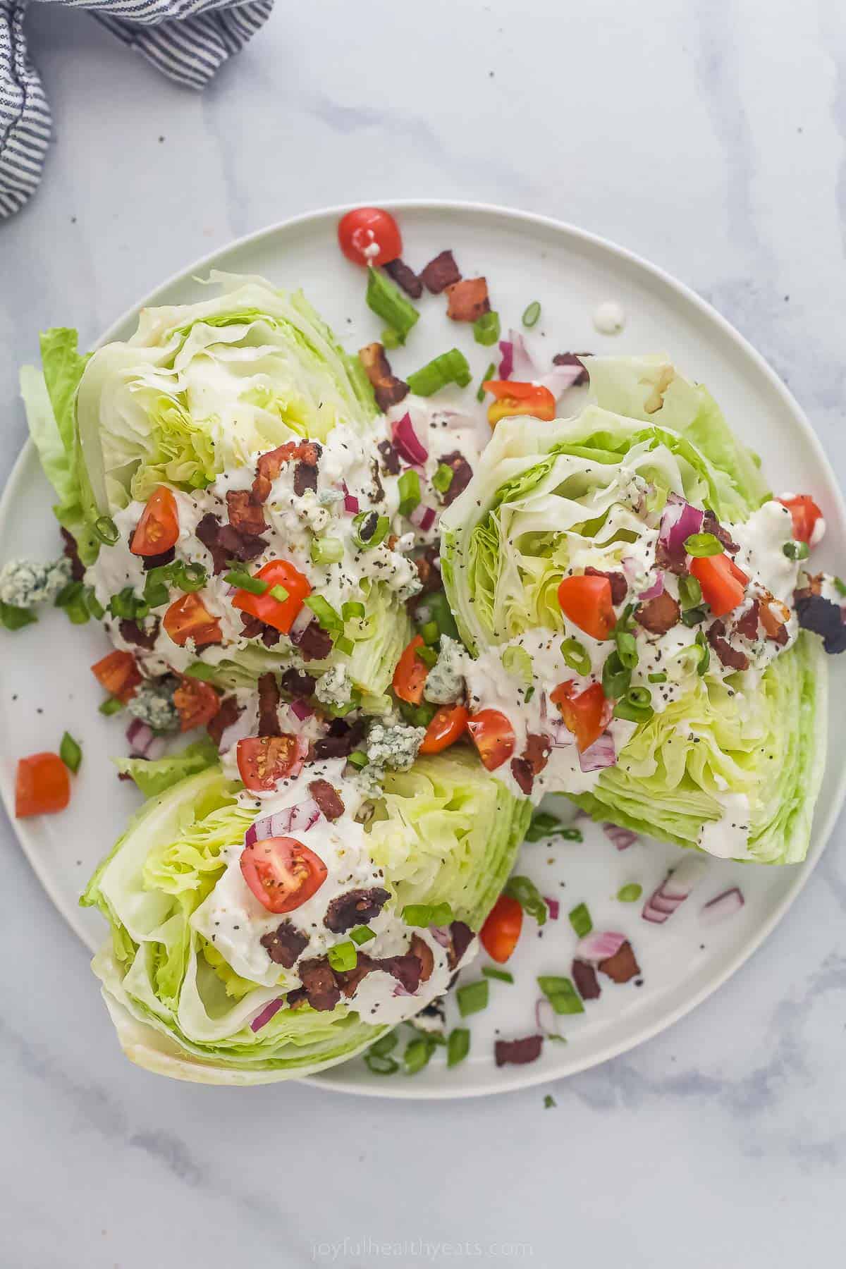 Wedge Salad with iceberg lettuce, tomatoes, bacon, red onions and creamy dressing