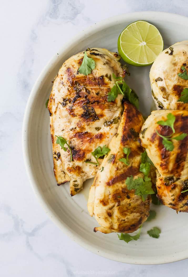 grilled cilantro lime chicken on a plate topped with fresh cilantro