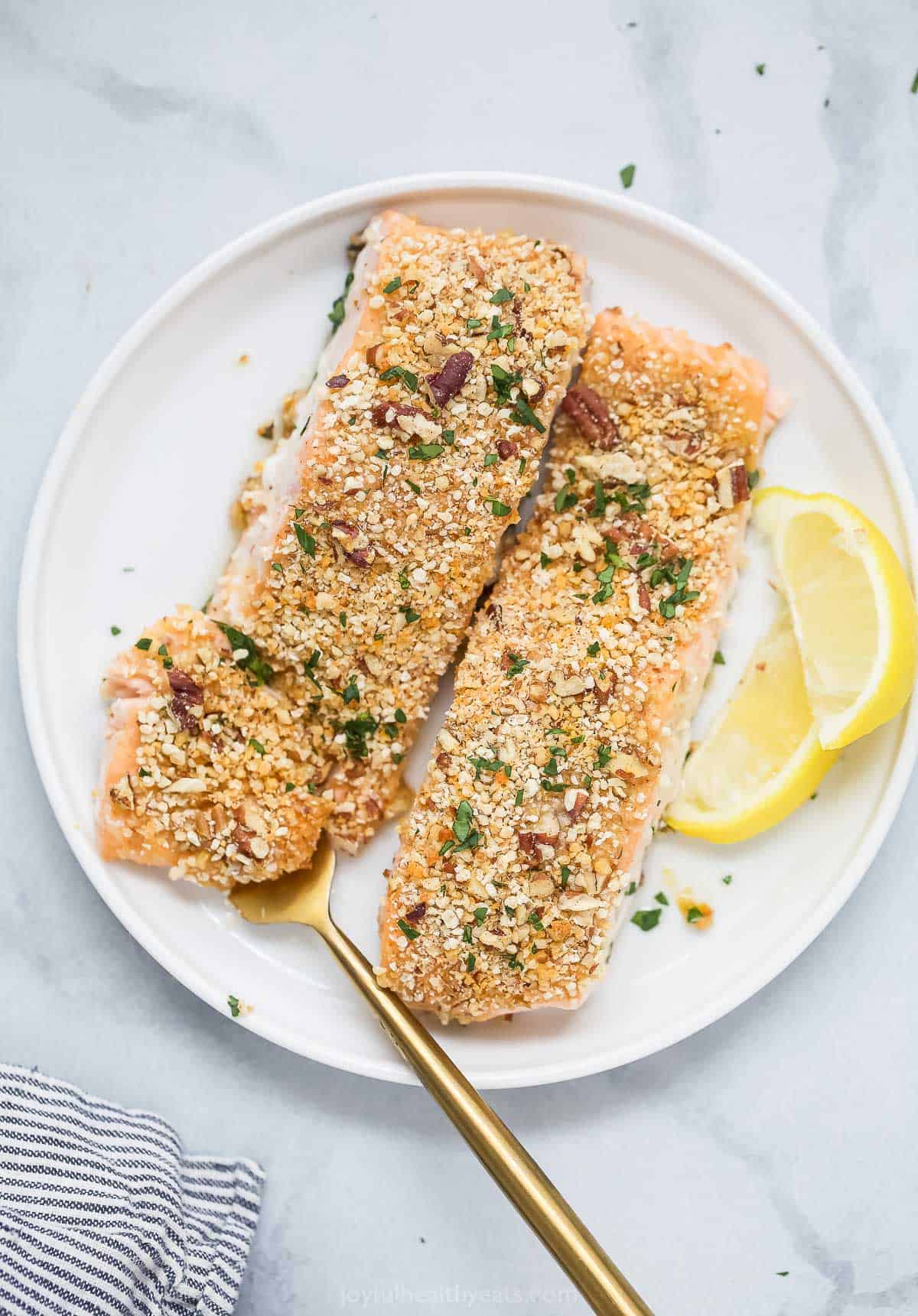 Two pecan crusted salmon filets on a plate.