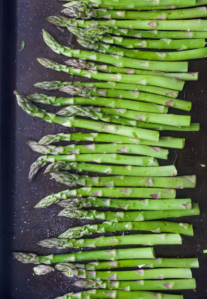 raw asparagus on a baking sheet