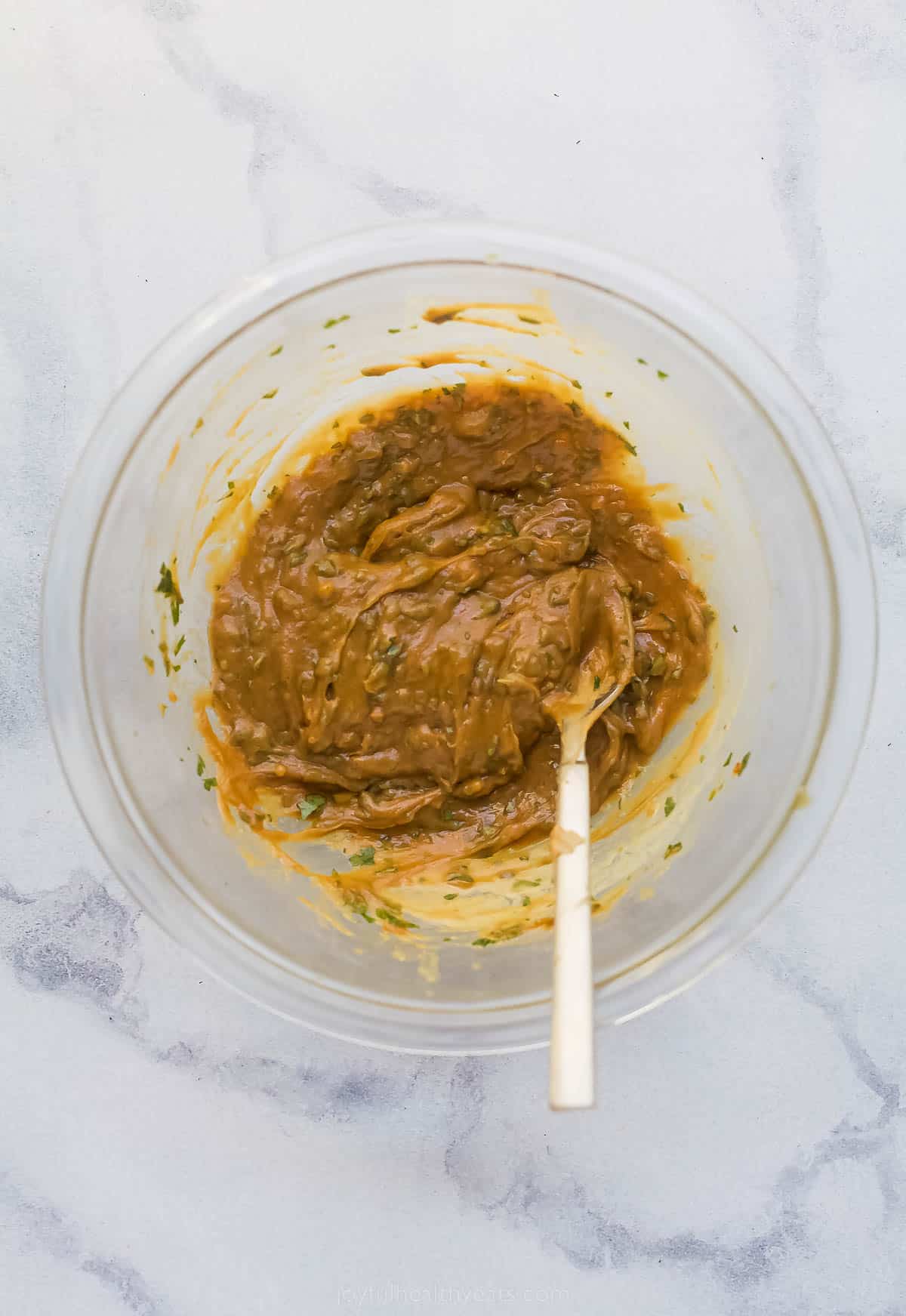 spicy thai peanut sauce being mixed in a bowl