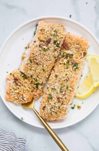 Two pecan crusted salmon filets on a plate.