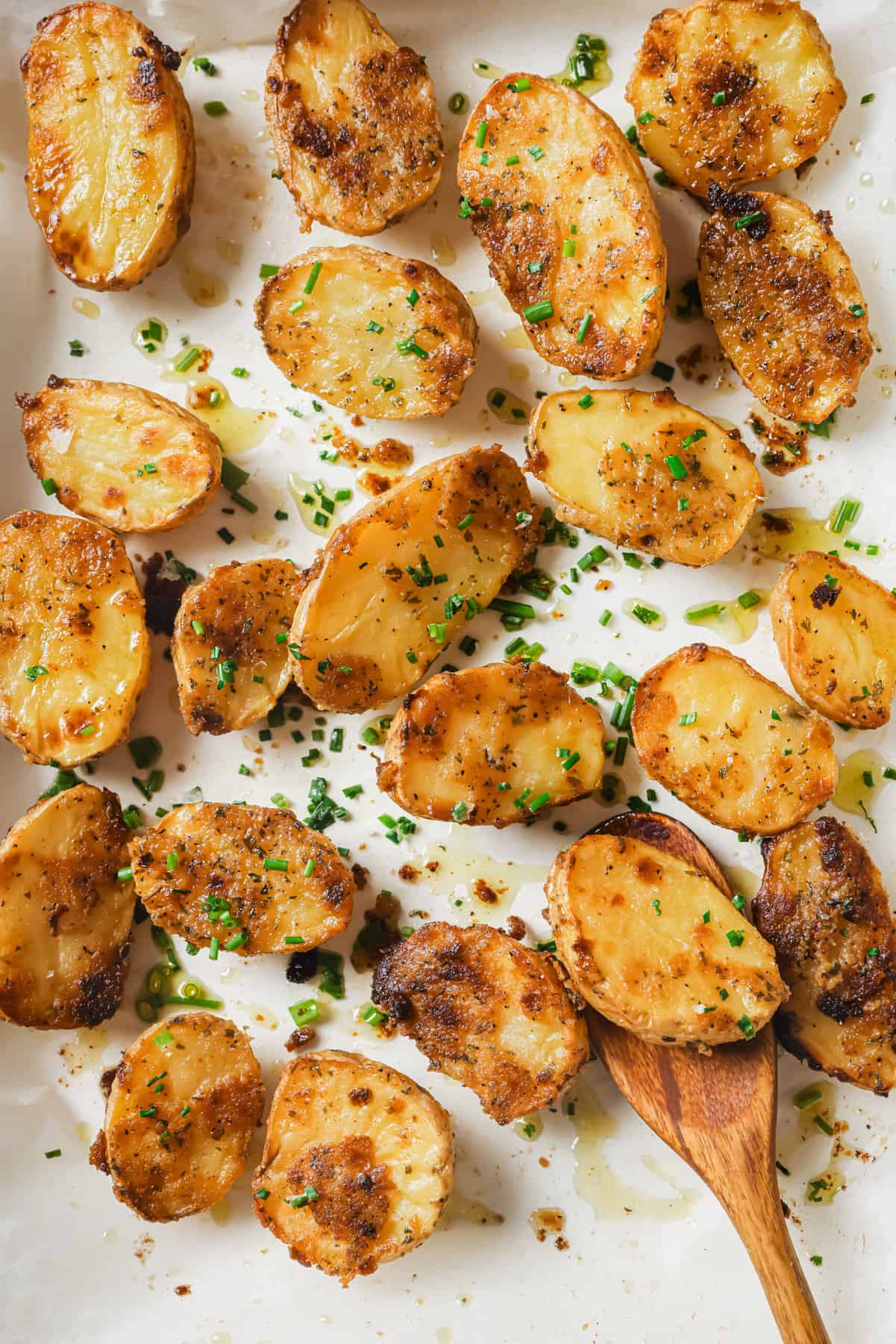 These garlic ranch potatoes are an easy baked side that'll make everyone happy with their crispy exterior and buttery center. Photo of golden roasted potatoes with ranch dressing seasoning.