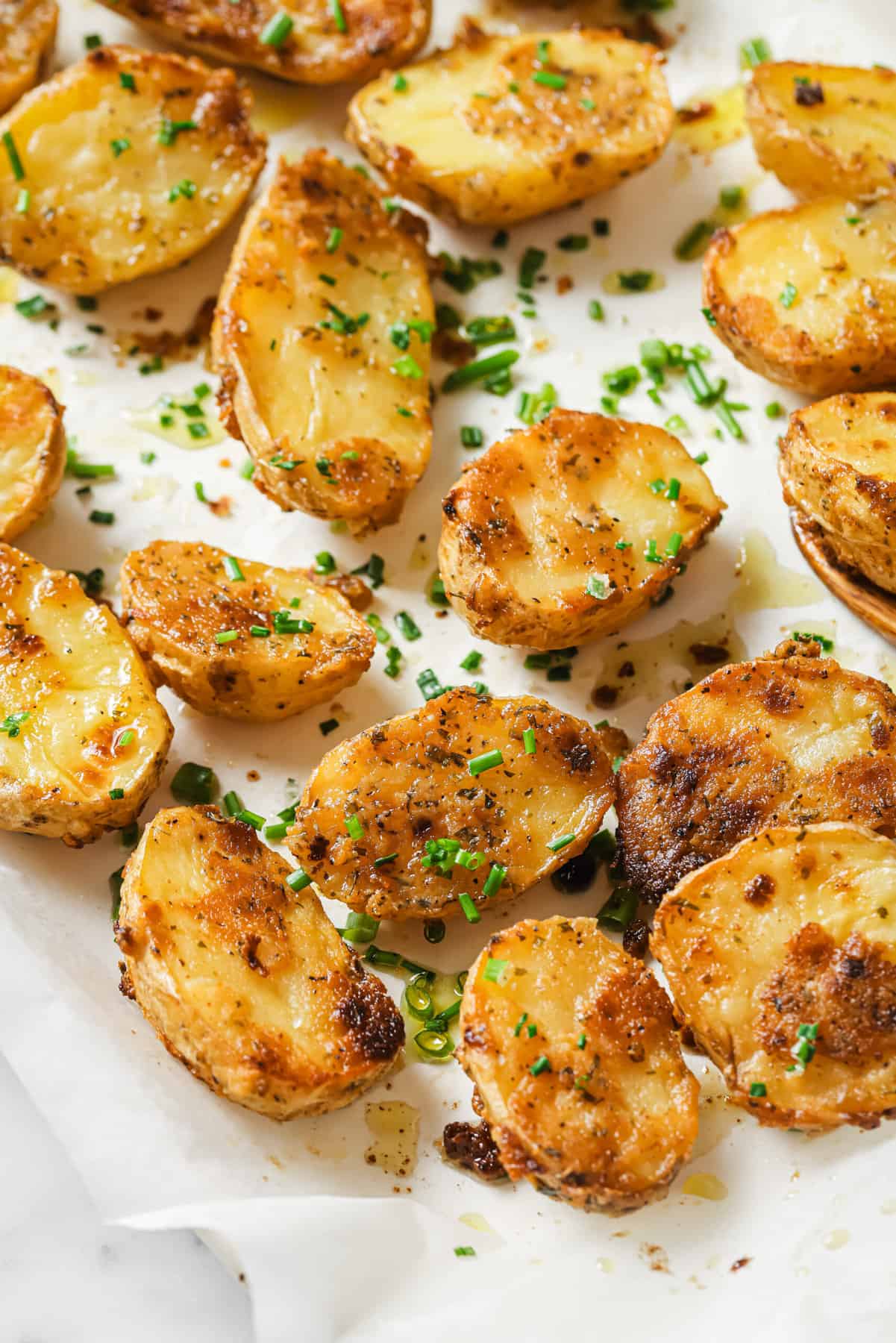 These garlic ranch potatoes are an easy baked side that'll make everyone happy with their crispy exterior and buttery center. Angled photo of roasted potatoes recipe.