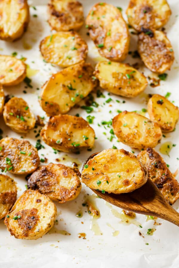 Close-up of a roasted potato on a wooden spoon.