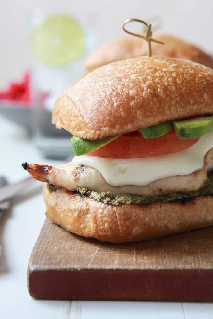 Close-up of a Grilled Avocado Caprese Chicken Sandwich on a wooden board