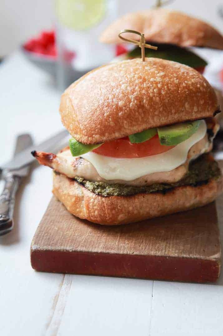 Grilled Avocado Caprese Chicken Sandwich on a wooden board