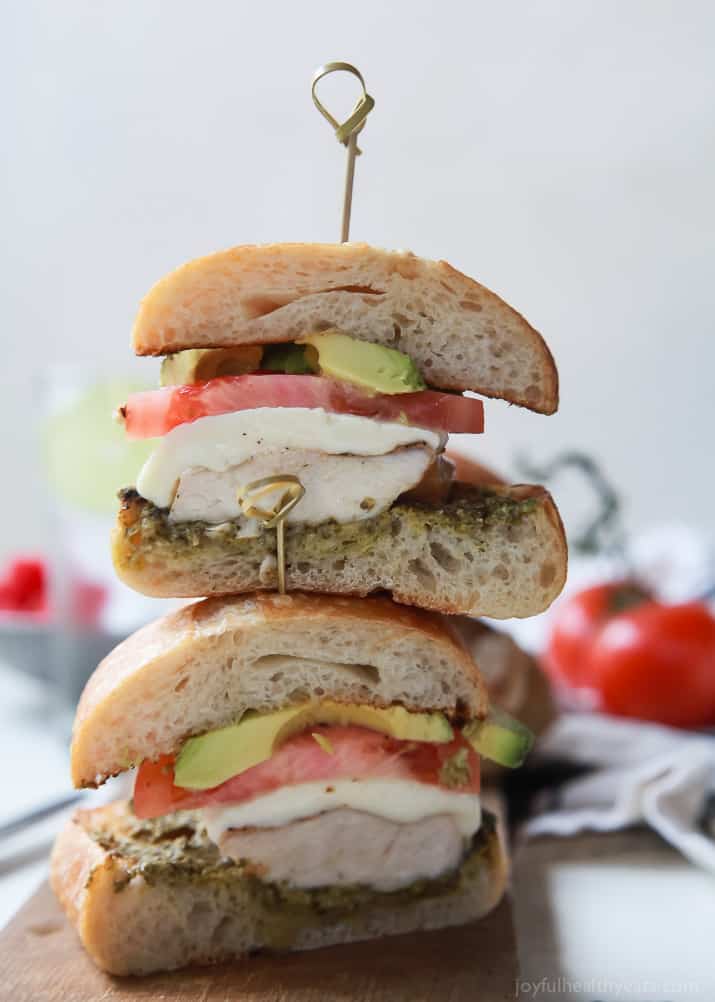 Two halves of a Grilled Avocado Caprese Chicken Sandwich stacked on top of each other