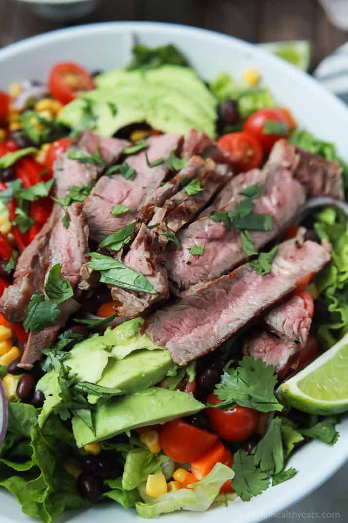 An easy healthy Southwestern Steak Salad loaded with vegetables, tender Ribeye Steak and then topped with a homemade Cilantro Avocado Dressing! Done in 15 minutes, low on calories and rivals any restaurant salad! | joyfulhealthyeats.com #glutenfree
