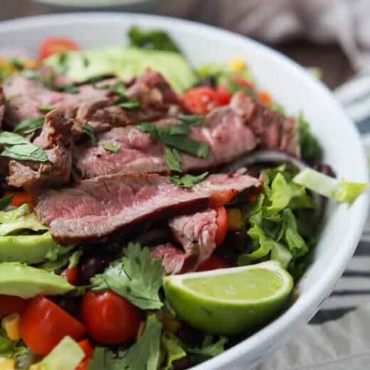 An easy healthy Southwestern Steak Salad loaded with vegetables, tender Ribeye Steak and then topped with a homemade Cilantro Avocado Dressing! Done in 15 minutes, low on calories and rivals any restaurant salad! | joyfulhealthyeats.com #glutenfree