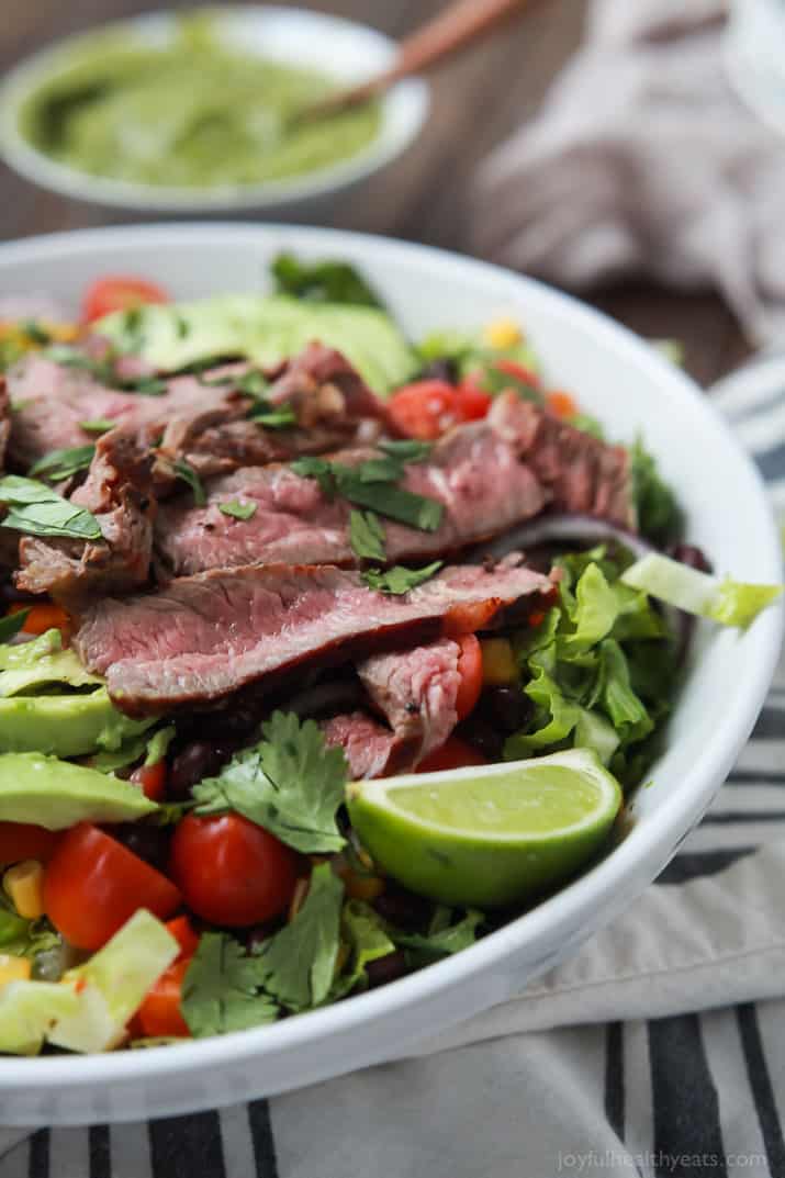 An easy healthy Southwestern Steak Salad loaded with vegetables, tender Ribeye Steak and then topped with a homemade Cilantro Avocado Dressing! Done in 15 minutes, low on calories and rivals any restaurant salad! | joyfulhealthyeats.com #glutenfree
