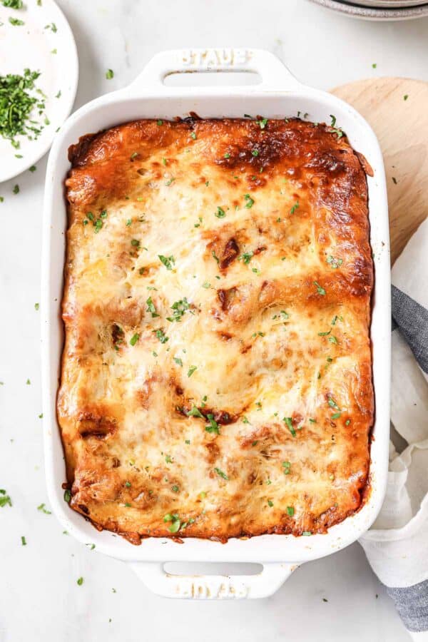 Lasagna rolls in the baking dish with melty mozzarella on top.