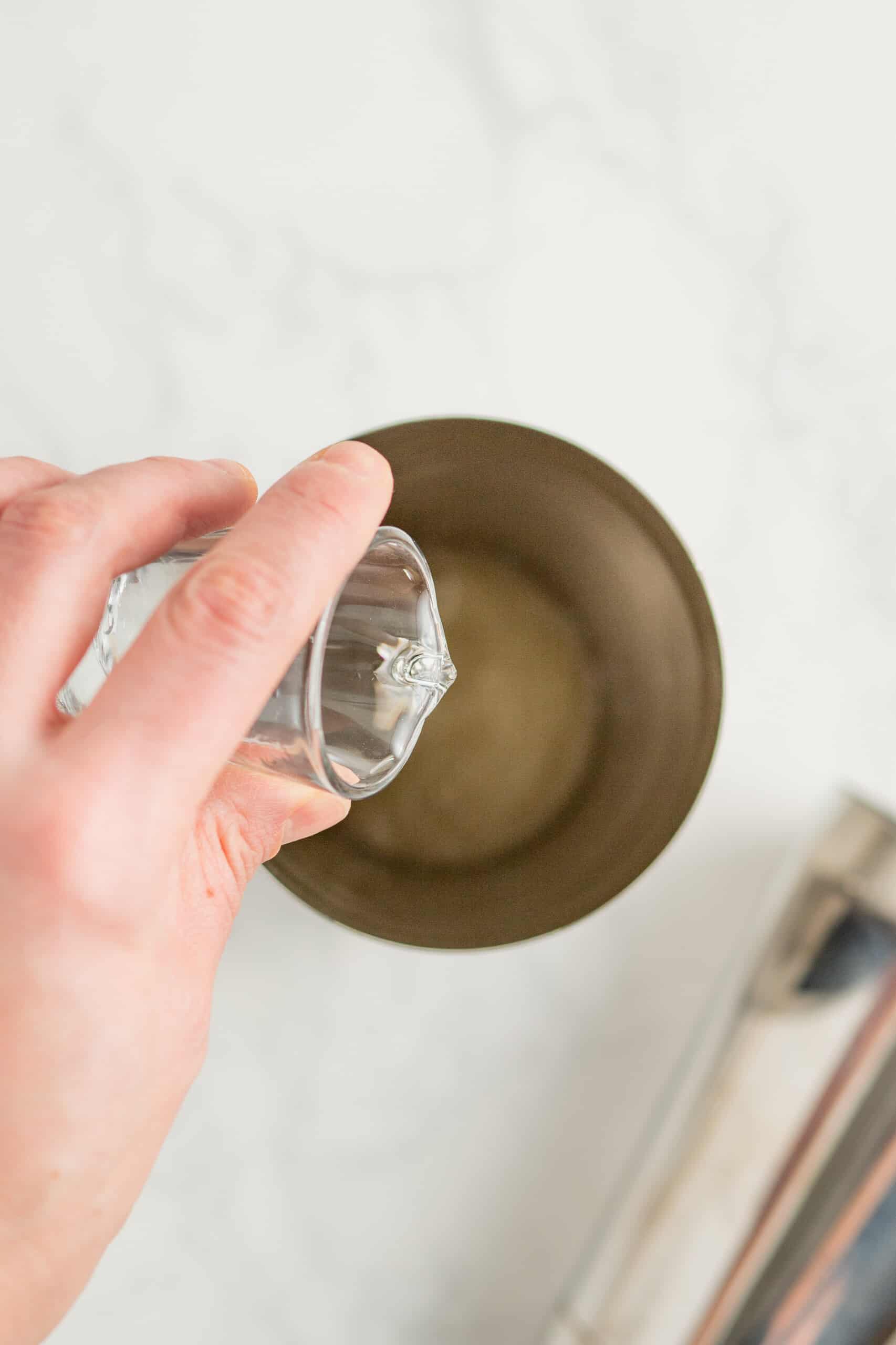 pouring liquor into a cocktail shaker