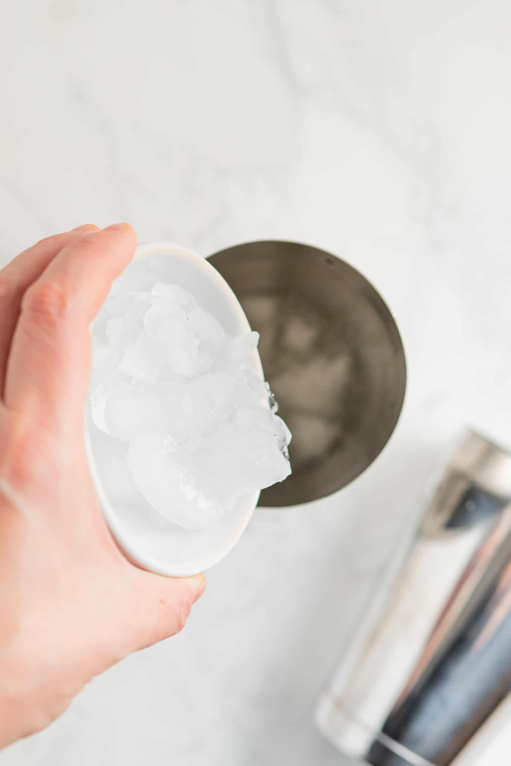 pouring ice into a cocktail shaker